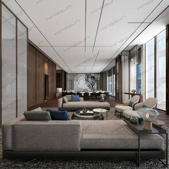 Hotel sitting room with tall windows, grouped seating and hung work on the walls