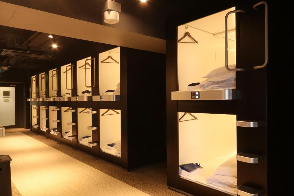 Interior corridor lined with fitted sleeping berths under even ceiling lighting